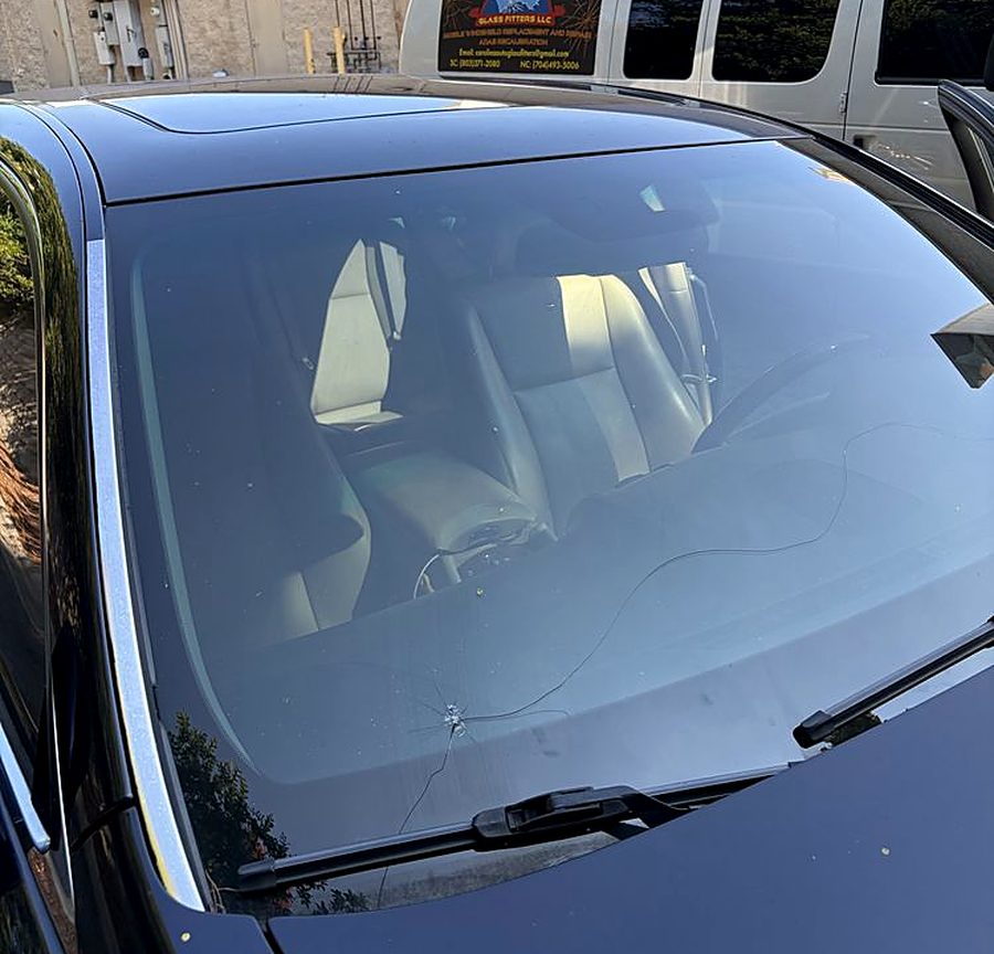 Freshly installed windshield on a black sedan with the Carolina Autoglass Fitters service van parked behind it in Rock Hill, SC