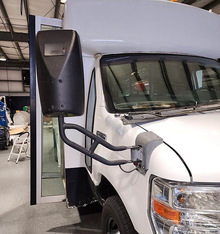 Large West Coast side view mirror on a white box truck being replaced at the customer's premises